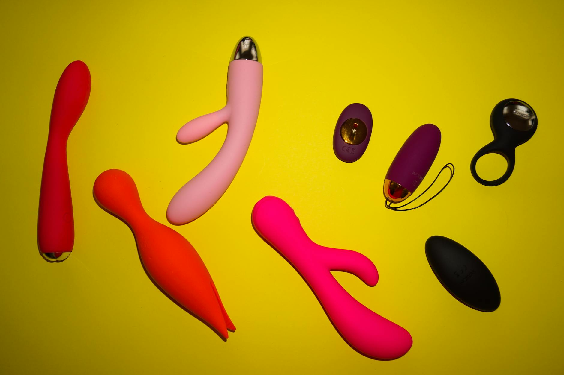 Vibrant collection of colorful personal massagers on a bright yellow surface