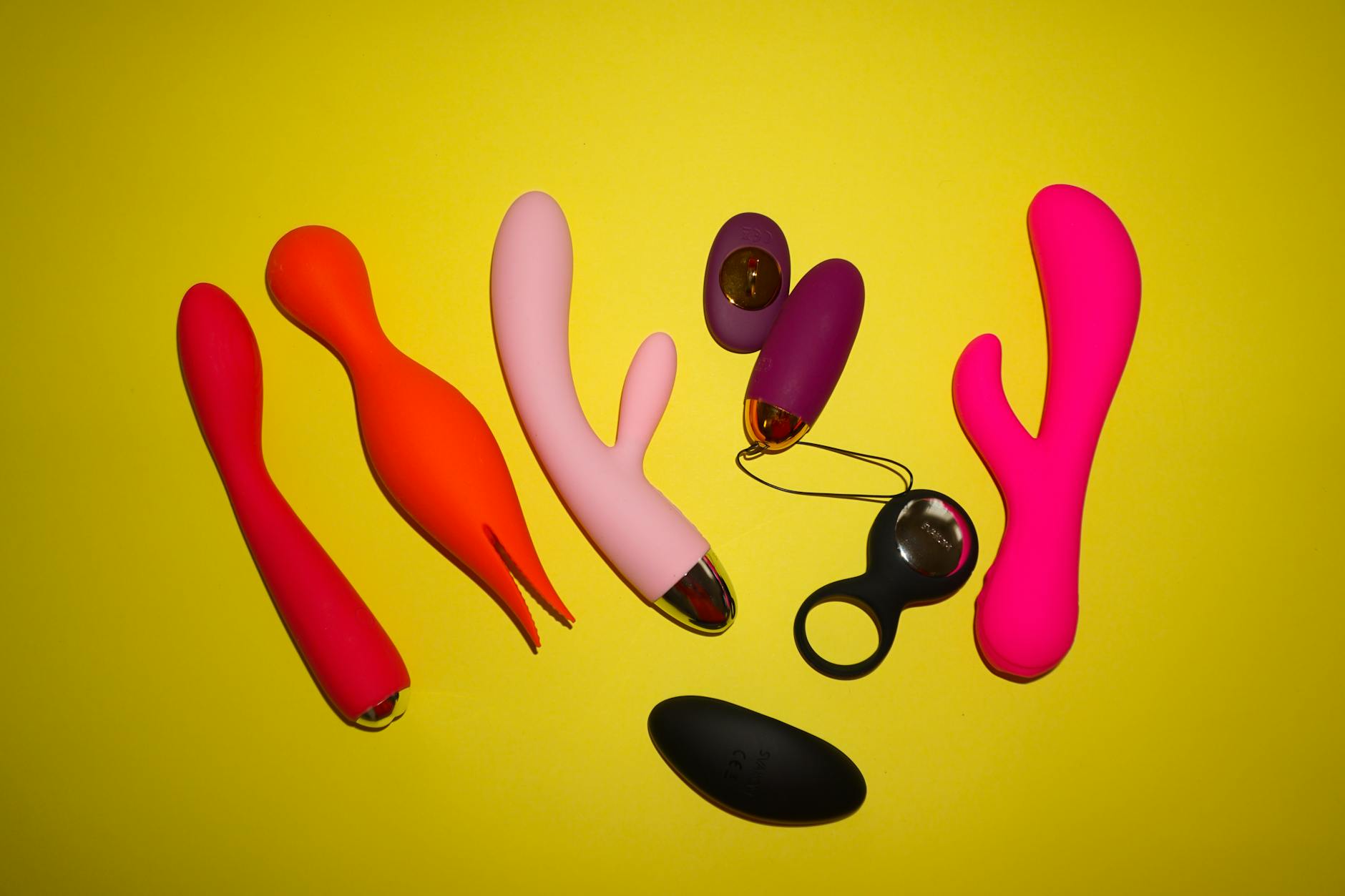 Colorful sex toys on bright background representing beginner-friendly clitoral vibrators